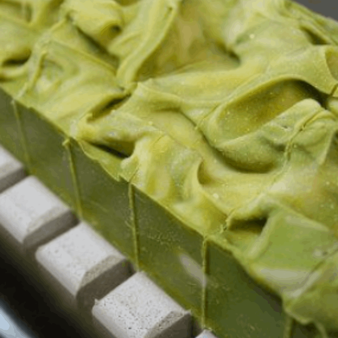 Luxurious best bar soap made with cucumber slices, lemon slices, and aloe vera leaves on a wooden cutting board. Mabrooka 